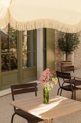 a table with a vase of flowers on a patio at Mas de l'Etoile in Aureille