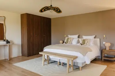 a bedroom with two beds and a wooden cabinet at Mas de l'Etoile in Aureille
