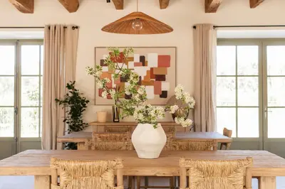a dining room with a table with a vase of flowers at Mas de l'Etoile in Aureille