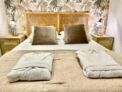 a bed with two towels on it with two tables at Entre Sorgue et sens in LʼIsle-sur-la-Sorgue