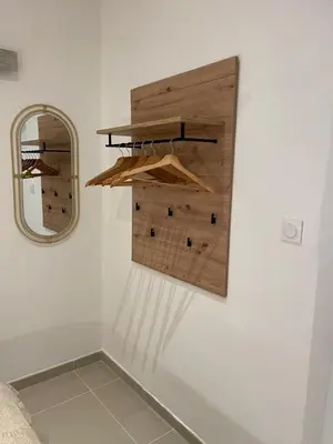 a wall with a mirror and some wooden shelves at Entre Sorgue et sens in LʼIsle-sur-la-Sorgue