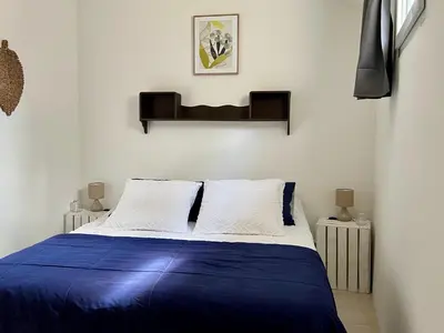 a bedroom with a bed with blue sheets and white pillows at L'Ecrin de Mérindol in Mérindol