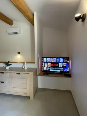 a living room with a flat screen tv on a wall at La tanière d'Agoult in Goult