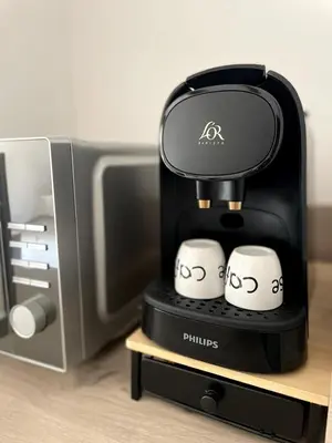 a coffee maker with two cups in front of a tv at La tanière d'Agoult in Goult