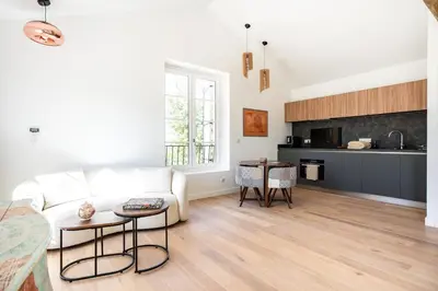 a living room with a white couch and a kitchen at Havre de Paix en Provence in Aix-en-Provence