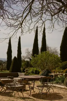 a picnic table and chairs in a park with trees at Havre de Paix en Provence in Aix-en-Provence