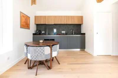 a kitchen with a table and chairs in a room at Havre de Paix en Provence in Aix-en-Provence