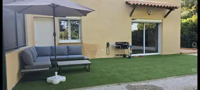 a patio with a couch and an umbrella and a grill at Maison de campagne in Salon-de-Provence