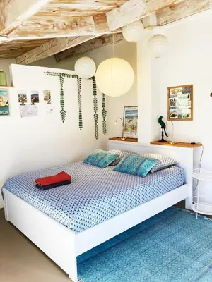 a bedroom with a bed with a red suitcase on it at Les oliviers in Saignon