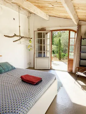 a bedroom with a bed with a red bag on it at Les oliviers in Saignon