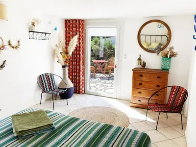 a bedroom with a bed and two chairs and a mirror at Les oliviers in Saignon