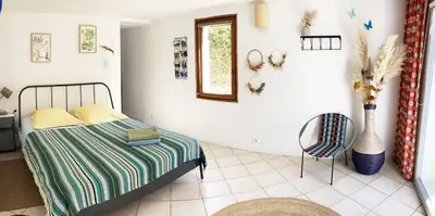 a bedroom with a bed and a chair at Les oliviers in Saignon