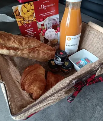 a basket of bread and a bottle of orange juice at L'Escale Pernoise, 2-6 personnes in Pernes-les-Fontaines