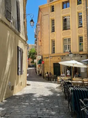 an empty street with tables and umbrellas in a city at inactive in Aix-en-Provence