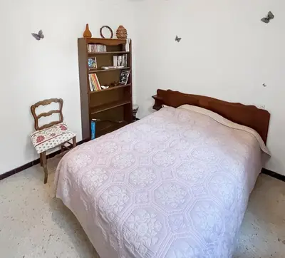 a bedroom with a bed and a chair and a book shelf at Les Terrasses de l'Adrech in Banon