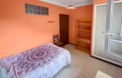 a bedroom with an orange wall with a bed and a closet at Les Terrasses de l'Adrech in Banon