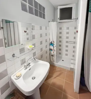 a white bathroom with a sink and a shower at Les Terrasses de l'Adrech in Banon