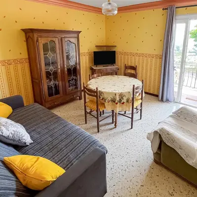 a bedroom with two beds and a table and a television at Les Terrasses de l'Adrech in Banon