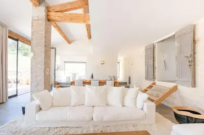 a living room with a white couch and a kitchen at La Bergerie Ferme du Montaiguet in Aix-en-Provence