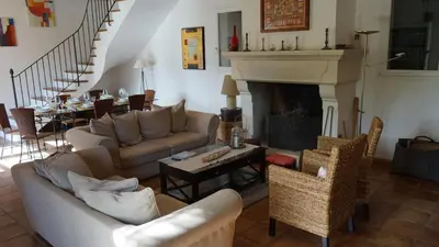 a living room with a couch and a fireplace at Bastide Clementine in LʼIsle-sur-la-Sorgue