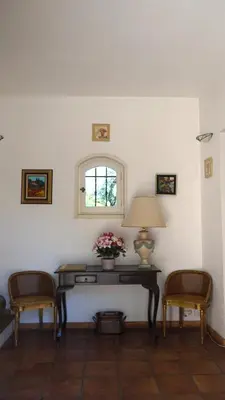 a room with a table with a lamp and two chairs at Bastide Clementine in LʼIsle-sur-la-Sorgue