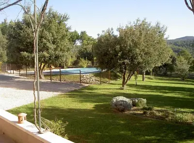 a yard with trees and a fence with a pool at Bastide Clementine in LʼIsle-sur-la-Sorgue