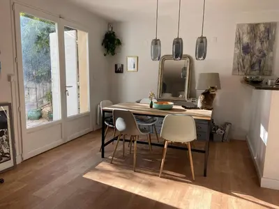a dining room with a table and chairs and a mirror at Maison village provençal in Éguilles