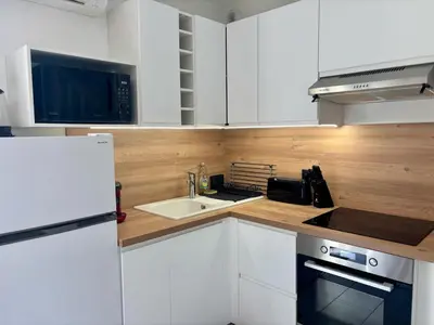 a kitchen with white cabinets and a sink and a microwave at Douceur de vivre en Provence in Saint-Saturnin-lès-Avignon