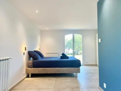 a bedroom with a bed with blue sheets and a window at Casa Corniou - Calme, Village Provençal, 3 chambres, 2 SDB, 8 personnes in Cornillon-Confoux
