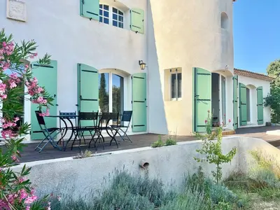 a house with green doors and chairs on a patio at Casa Corniou - Calme, Village Provençal, 3 chambres, 2 SDB, 8 personnes in Cornillon-Confoux