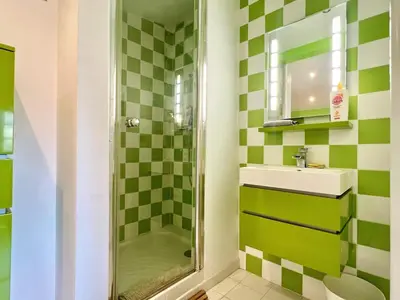 a bathroom with green and white checkered tiles at Casa Corniou - Calme, Village Provençal, 3 chambres, 2 SDB, 8 personnes in Cornillon-Confoux