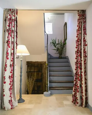 a hallway with a staircase with red and white curtains at Artist's Villa With Pool Near Aix-En-Provence in Alleins