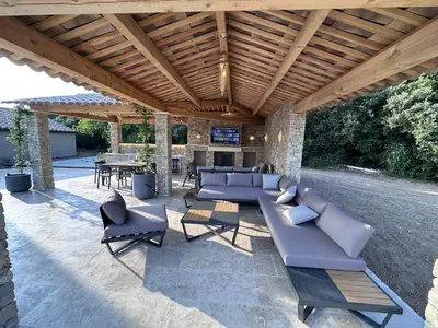 a patio with couches and chairs under a wooden roof at Keur Bouyo - Provençal Luxury Retreat in Saint-Saturnin-les-Apt