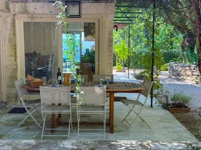 a wooden table and chairs in a patio at Mas à Gordes avec piscine et vue incroyable à 900m du village in Gordes