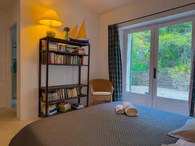 a bedroom with a canopy bed and a living room at Mas à Gordes avec piscine et vue incroyable à 900m du village in Gordes