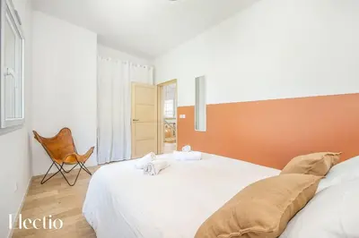 a bedroom with a large white bed and a chair at Cabane dIsmou Pool & Wood Design in La Roque-dʼAnthéron
