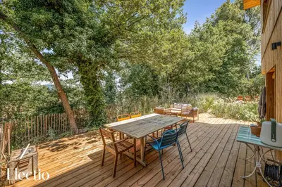 a wooden deck with a table and chairs on it at Cabane dIsmou Pool & Wood Design in La Roque-dʼAnthéron