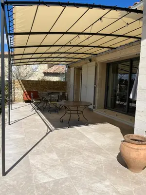 a patio with a table and benches on it at Maison dans un hameau avec piscine in Gordes