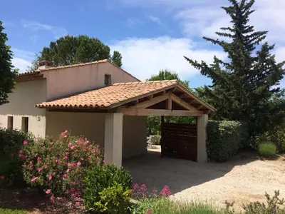 a garage with a brown door in front of a house at Le clos de la Touloubre in Aix-en-Provence