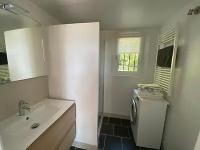 a bathroom with a sink and a washing machine at Le clos de la Touloubre in Aix-en-Provence
