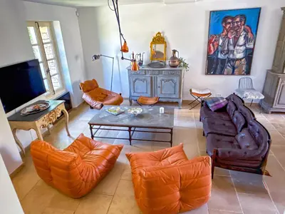 a living room with orange chairs and a table at Villa de vacances à Gordes avec piscine partagée, La Bastide de Léa in Gordes
