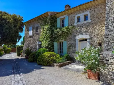 an old stone house with a driveway at Villa de vacances à Gordes avec piscine partagée, La Bastide de Léa in Gordes
