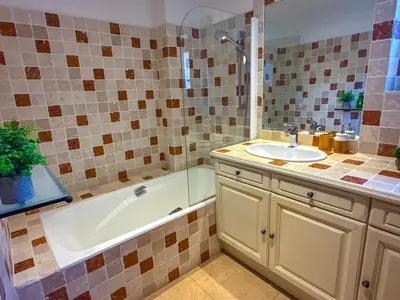 a bathroom with a bath tub and a sink at Villa de vacances à Gordes avec piscine partagée, La Bastide de Léa in Gordes