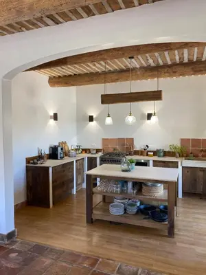 a large kitchen with a table in the middle at The Farmhouse in the shade of the plane trees in Cavaillon