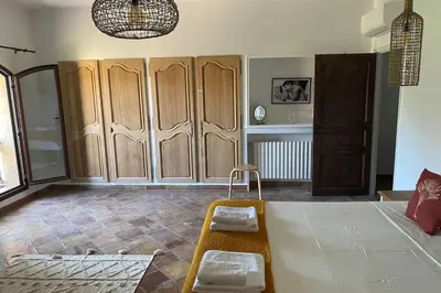 a living room with a bed and wooden cabinets at The Farmhouse in the shade of the plane trees in Cavaillon