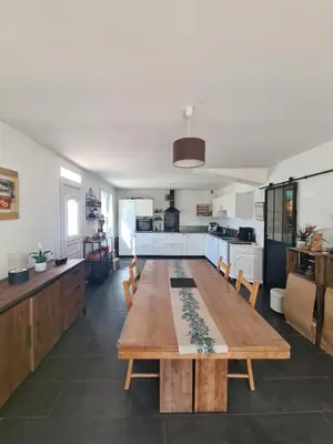 a living room with a wooden table and a kitchen at Villa avec piscine en Provence in Pernes-les-Fontaines