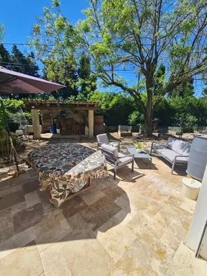 a patio with a table and two chairs and a gazebo at Villa avec piscine en Provence in Pernes-les-Fontaines