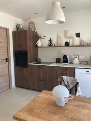a kitchen with wooden cabinets and a wooden table at La Petite Bastide en Provence in Noves