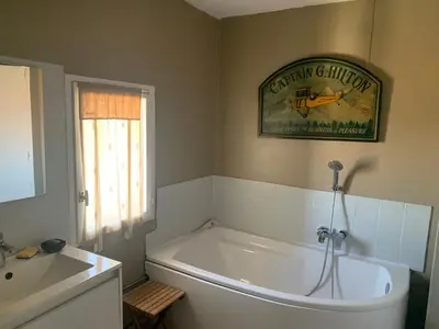 a bathroom with a large white tub and a sink at Charming village house in Alleins