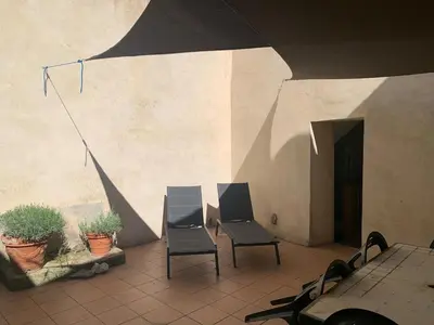 a brick building with a garage and a stairway at Charming village house in Alleins